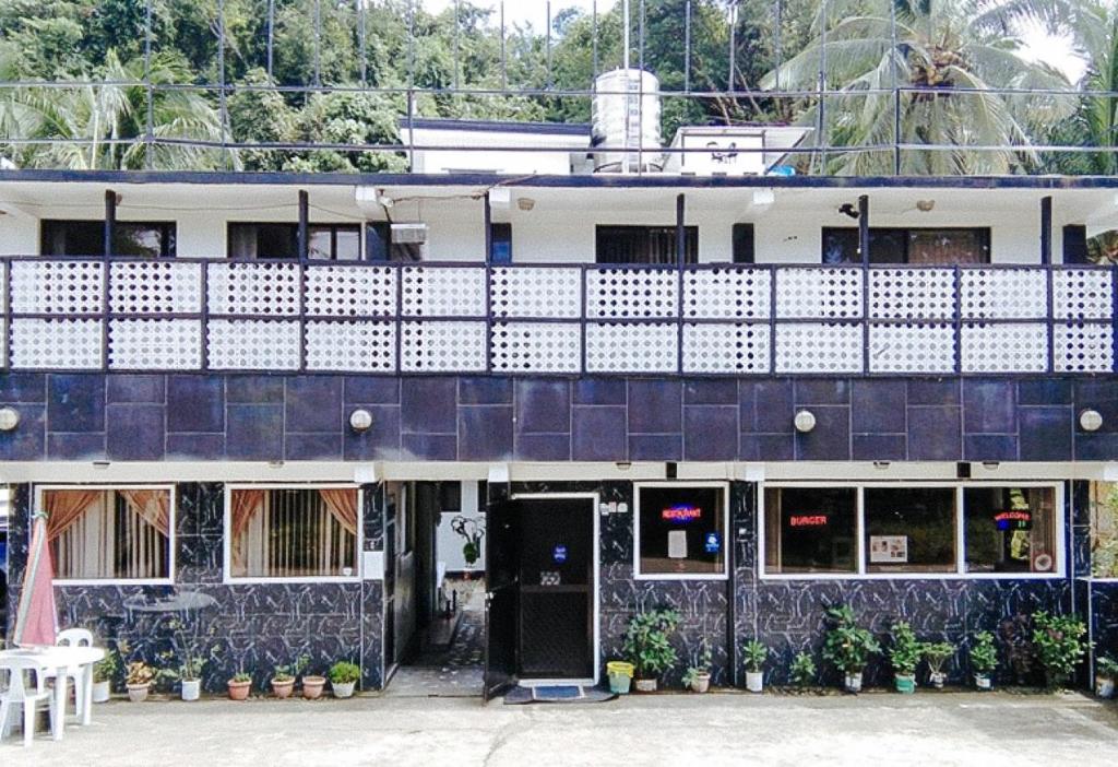 a blue and white building with a balcony at RedDoorz @ Western Highway Lodge Hotel in Marabut