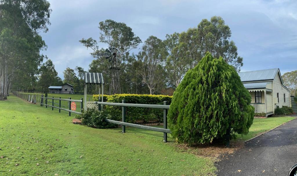 a fence and a bush in front of a house at Belvoir B&B Cottages in Grafton