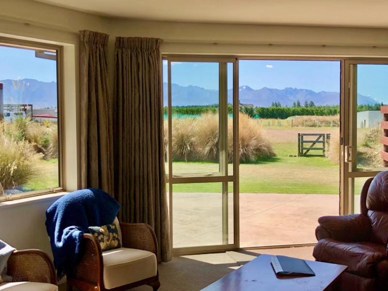 a living room with sliding glass doors with a view at Stunning 360-degree views in Twizel