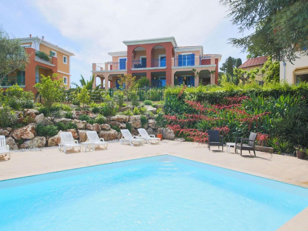 uma villa com uma piscina e uma casa em Picturesque flat with swimming pool em Roquefort Les Pins