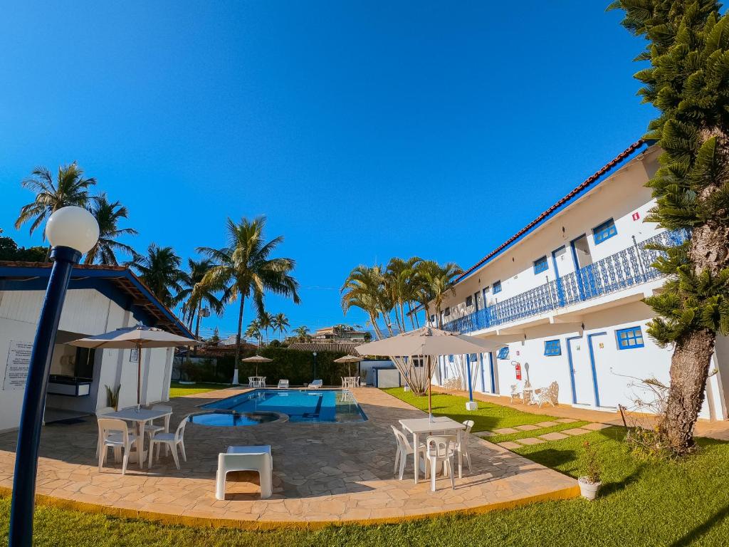 a hotel with a patio and a swimming pool at Hotel Arrastão in São Sebastião