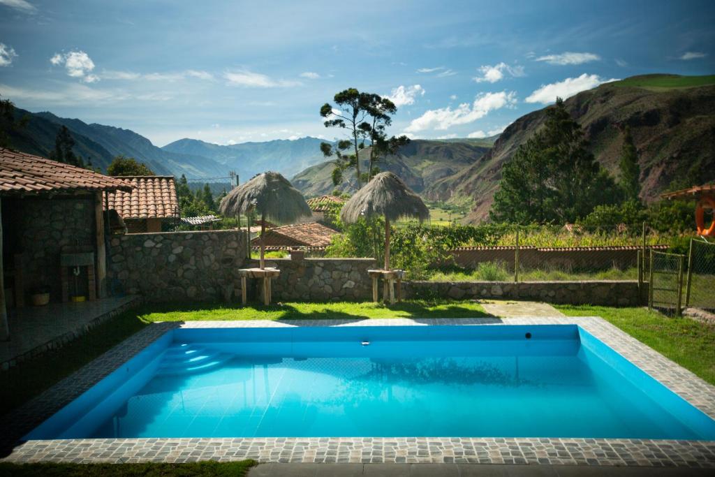 a swimming pool in a backyard with mountains in the background at Sacred Valley View in Urubamba