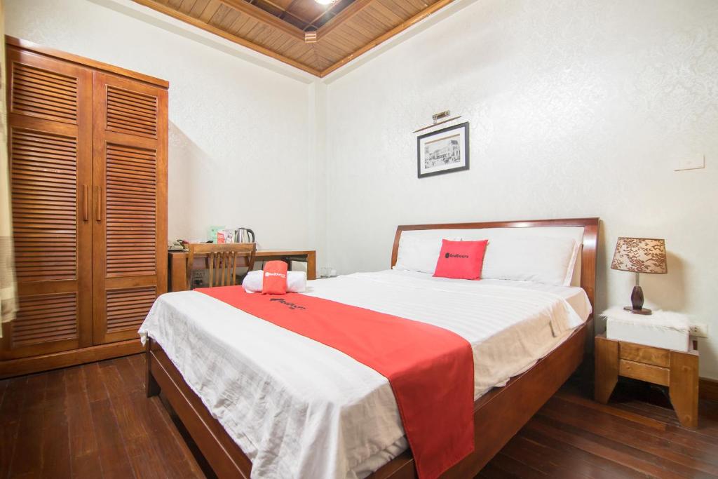 a bedroom with a large bed with a red blanket at Green Hotel near Lotte Center in Hanoi