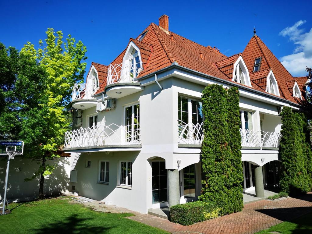 Casa blanca con techo rojo en Győrfi Apartmanház Zamárdi, en Zamárdi