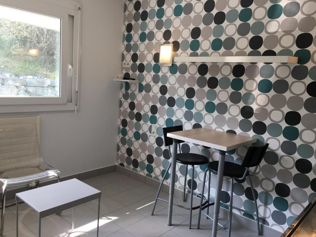 a room with a table and chairs and a wall with polka dots at STUDIO SUR LE PORT in Le Bourget-du-Lac