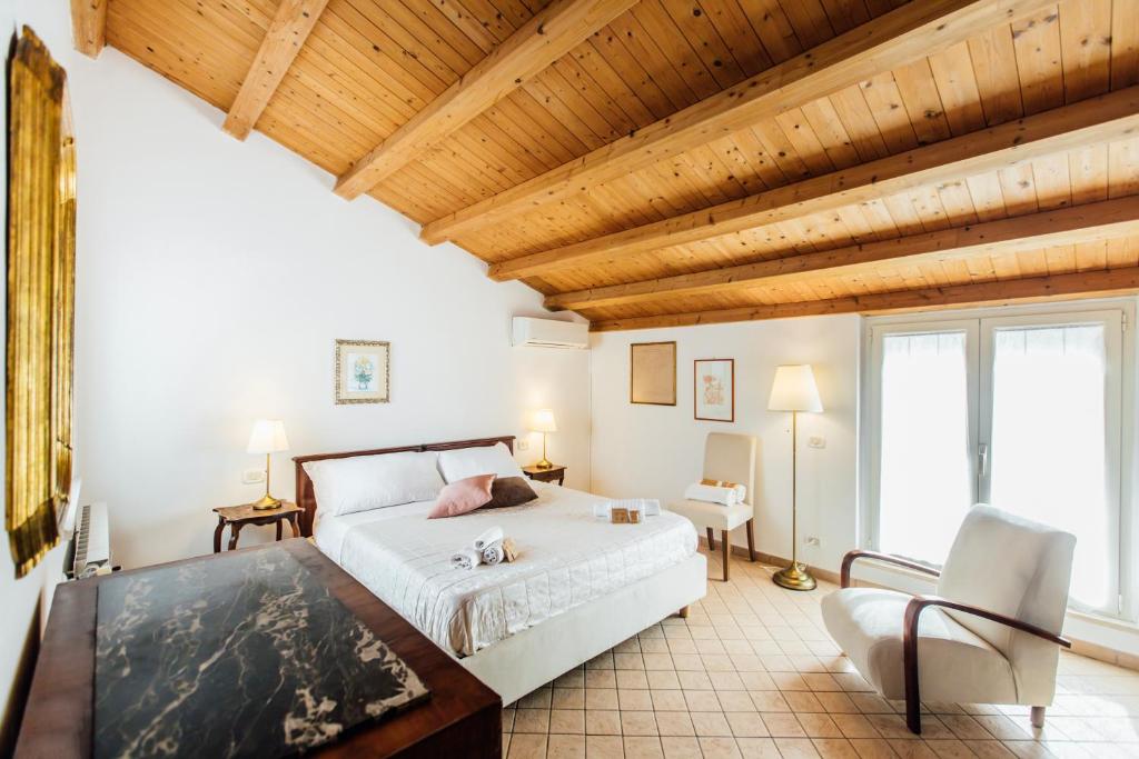 a bedroom with a large bed and a wooden ceiling at In Centro Residenza - Suites & Apartments in Vasto