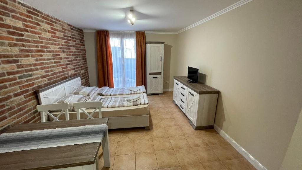 1 dormitorio con cama y pared de ladrillo en Dalma Apartment, en Gyula
