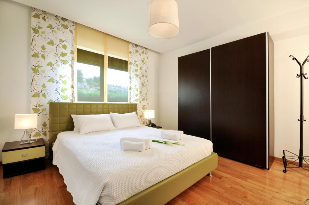 a bedroom with a large bed with two towels on it at Sani Polyastron Hotel & Spa in Sani Beach