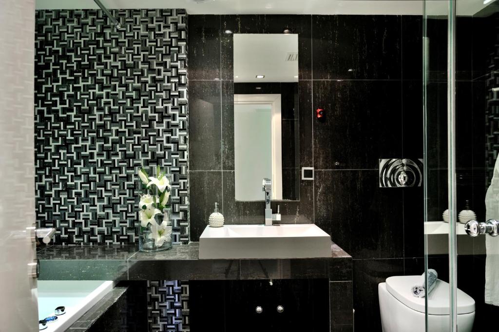 a bathroom with a sink and a toilet and a mirror at Sani Polyastron Hotel & Spa in Sani Beach