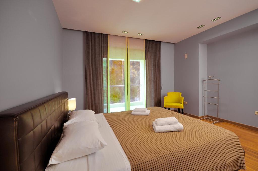 a bedroom with a large bed with two pillows on it at Sani Polyastron Hotel & Spa in Sani Beach