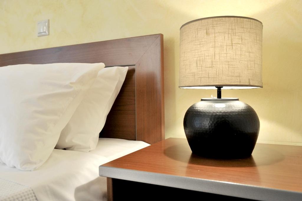 a black lamp sitting on a table next to a bed at Sani Polyastron Hotel & Spa in Sani Beach