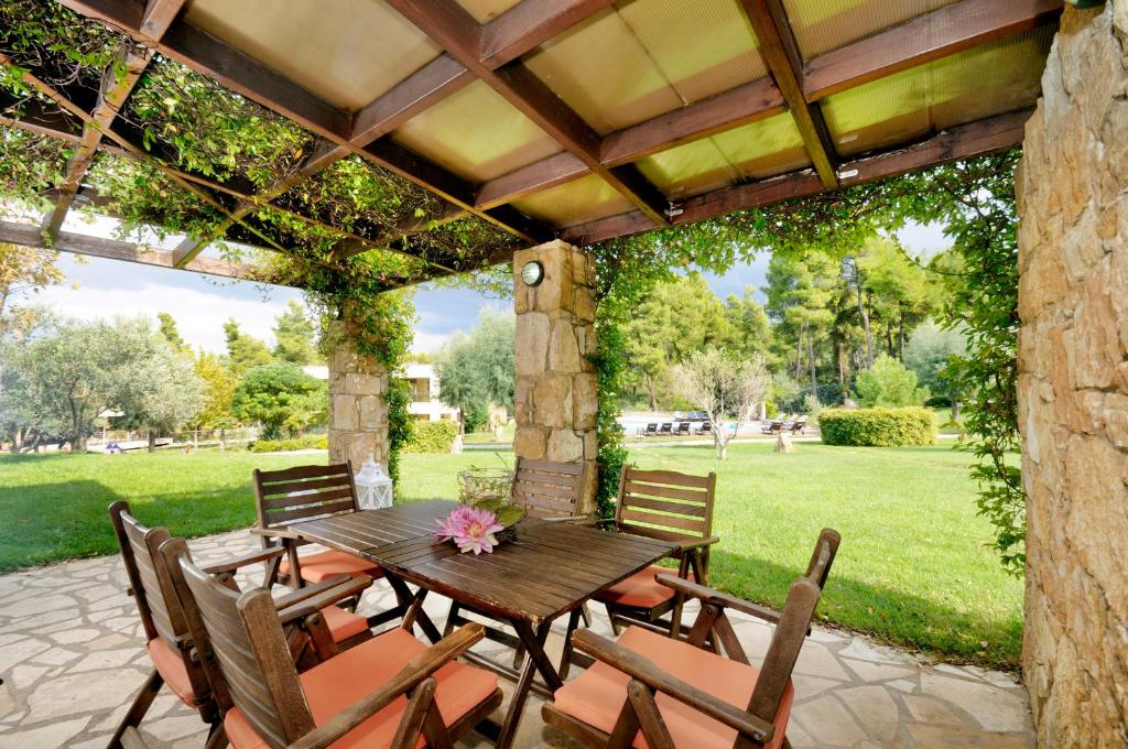 a wooden table and chairs on a patio at Sani Polyastron Hotel & Spa in Sani Beach
