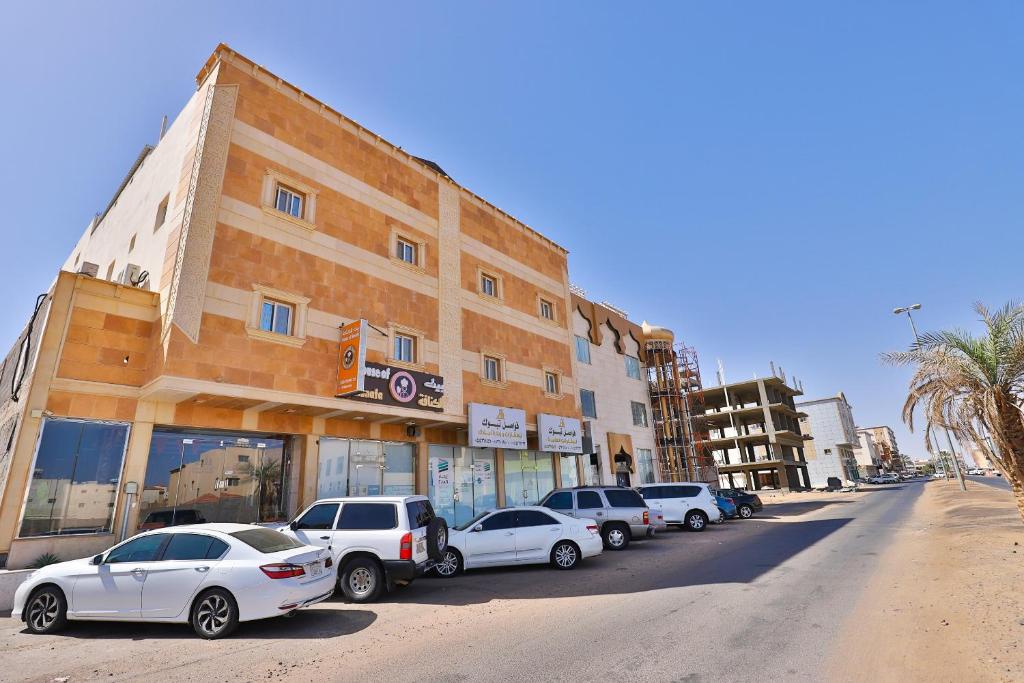 uma fila de carros estacionados em frente a um edifício em Fawasel Tabuk 2, Al Ulaya فواصل تبوك2 em Tabuk