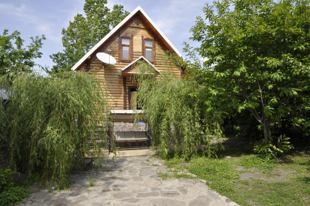 a wooden house with a porch and trees at Fairy Tale in Gabala