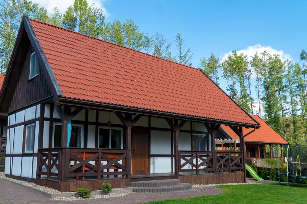 mały domek z pomarańczowym dachem w obiekcie Domek u Oliwii 13 Na Gwizdowce w mieście Załakowo