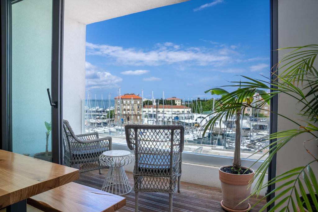 a balcony with chairs and a view of a harbor at Vanni apartment in Zadar