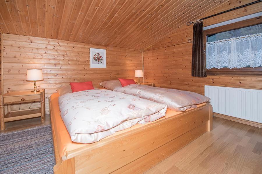 a bedroom with a bed in a wooden cabin at Haus am Wörtherberg in Rauris