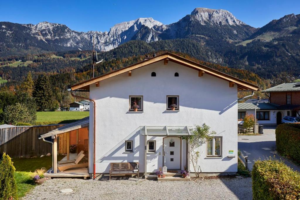 uma casa branca com montanhas ao fundo em Ferienhaus Kaffeesatz em Schönau am Königssee