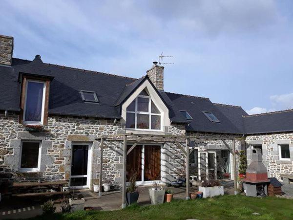 a stone house with a black roof at Entre Terre et Mer in La Méaugon