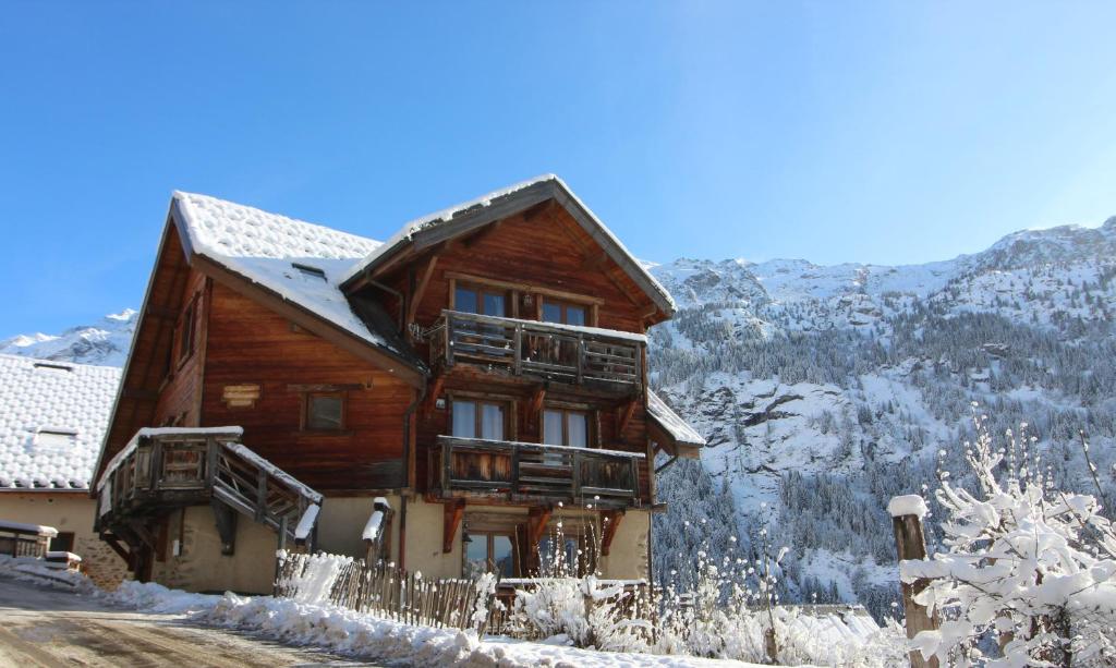 une grande maison en bois avec de la neige au sol dans l'établissement VAUJANYLOCATIONS - Le Grenier de Germaine, à Vaujany