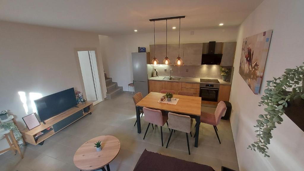 Una cocina y un comedor con mesa y sillas. en Holiday house BEDEM, en Marina