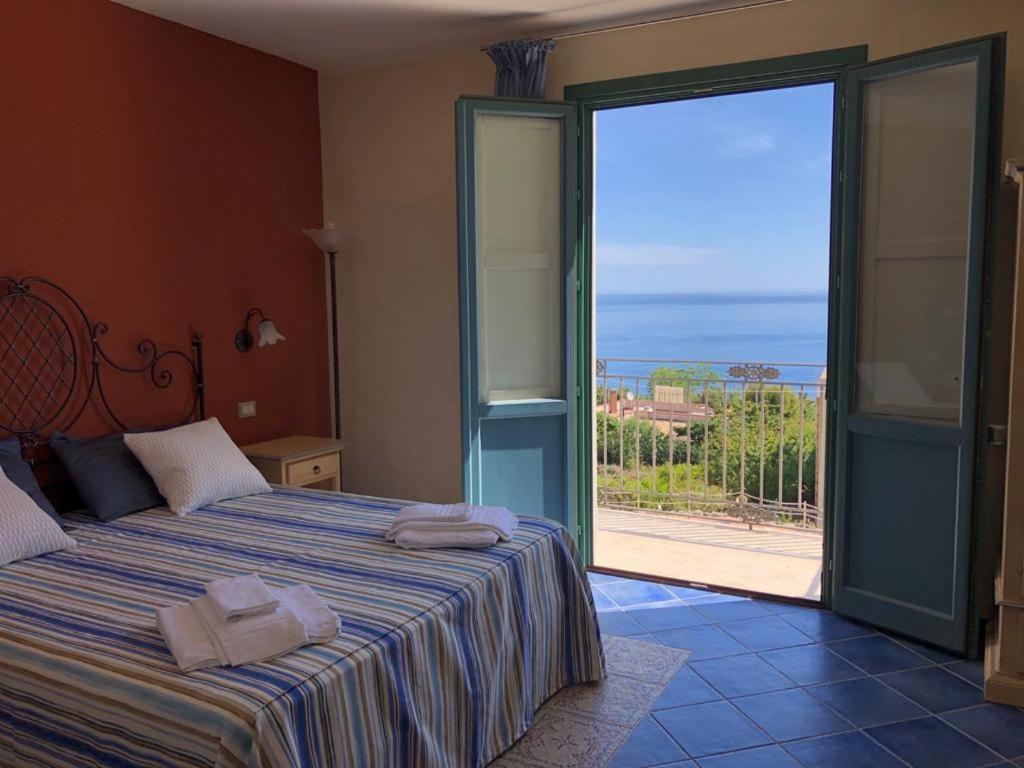 a bedroom with a bed with a view of the ocean at Baglio Dello Zingaro in Scopello