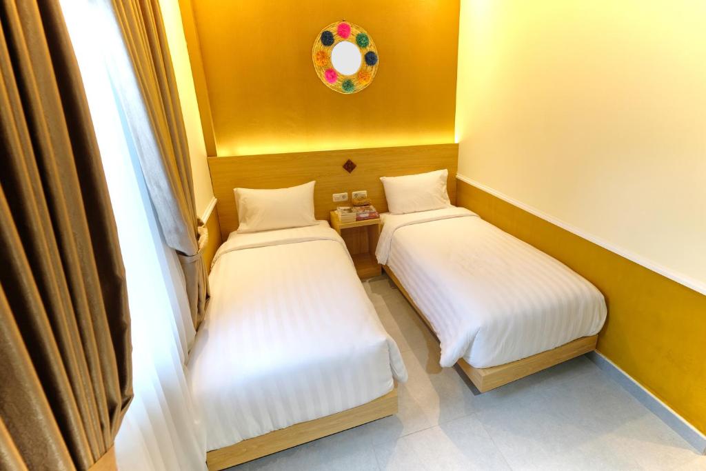 Postel nebo postele na pokoji v ubytování Americano Hotel Syariah Yogyakarta