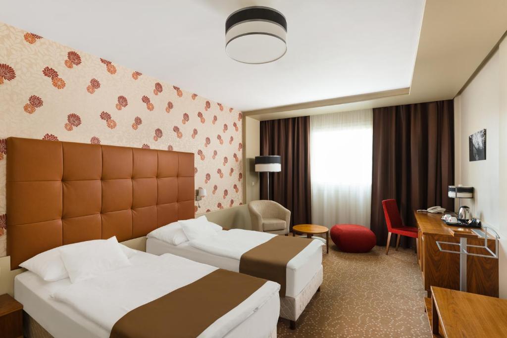 Postel nebo postele na pokoji v ubytování Corso Hotel Pécs