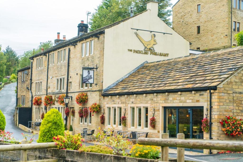 a building with a sign on the side of it at The Pickled Pheasant in Holmfirth