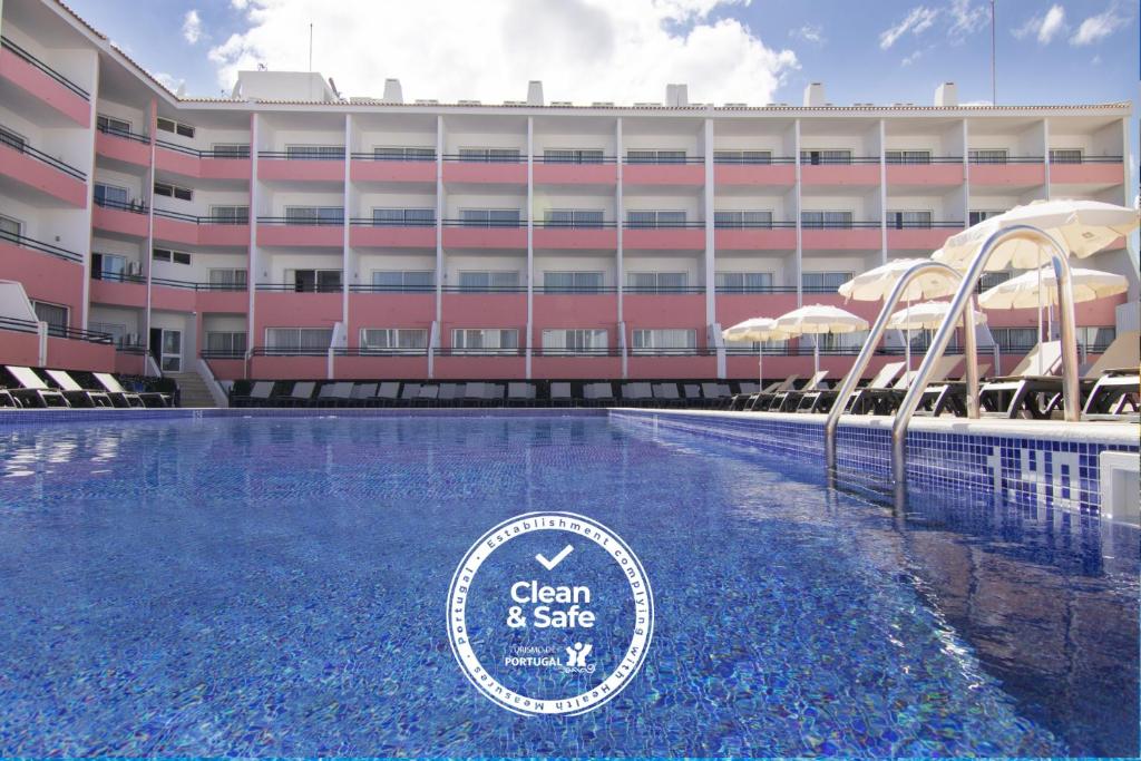 a hotel with a swimming pool in front of a building at Luna Hotel da Oura in Albufeira