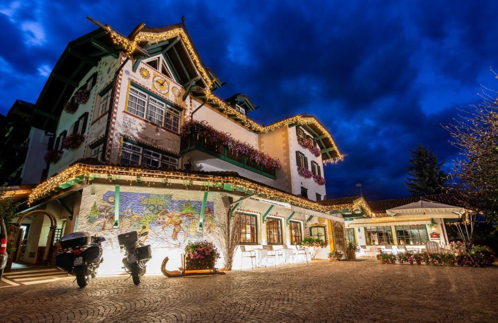 a building with a motorcycle parked in front of it at Hotel Piedibosco in Moena