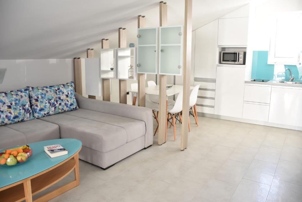 salon z kanapą i stołem w obiekcie Beachfront Apartments - Villa Vita w mieście Stara Novalja