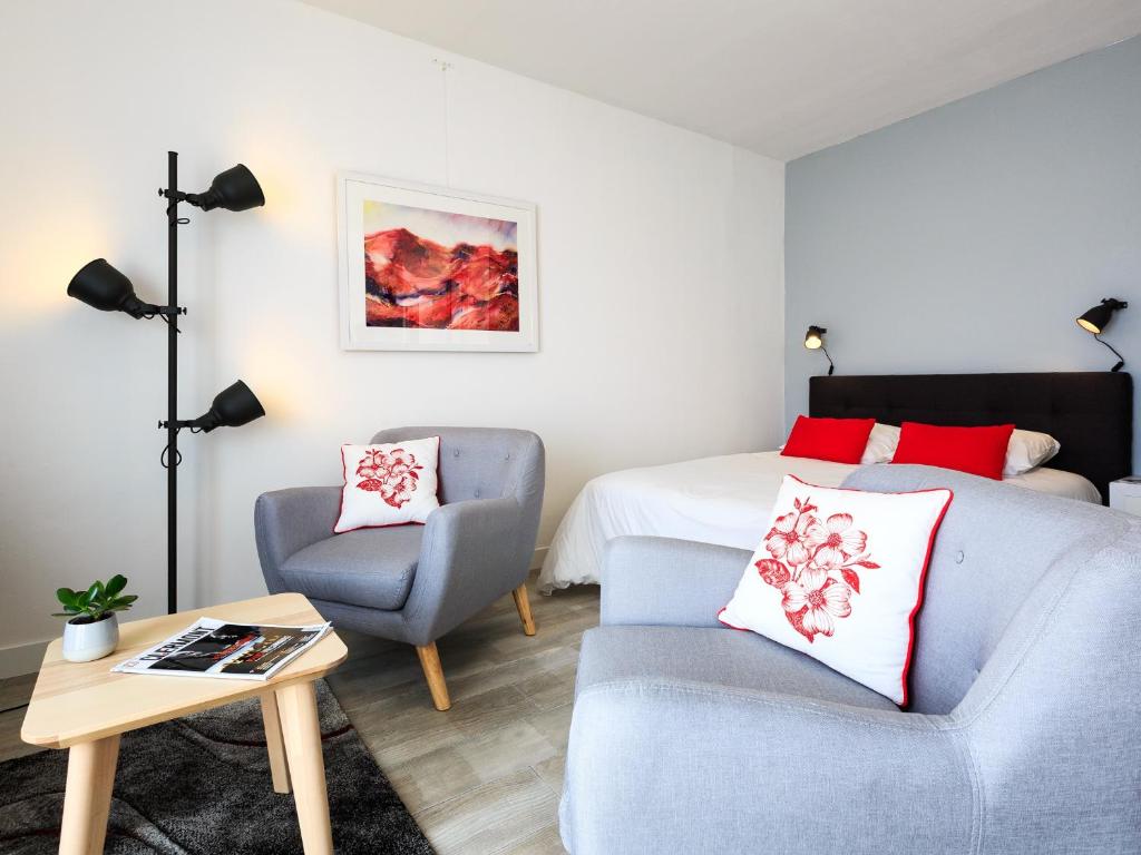 sala de estar con cama, sofá y silla en 1er Mai, en Clermont-Ferrand