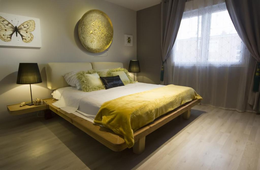 a bedroom with a large bed with a yellow blanket at Art Apartment in Rovinj