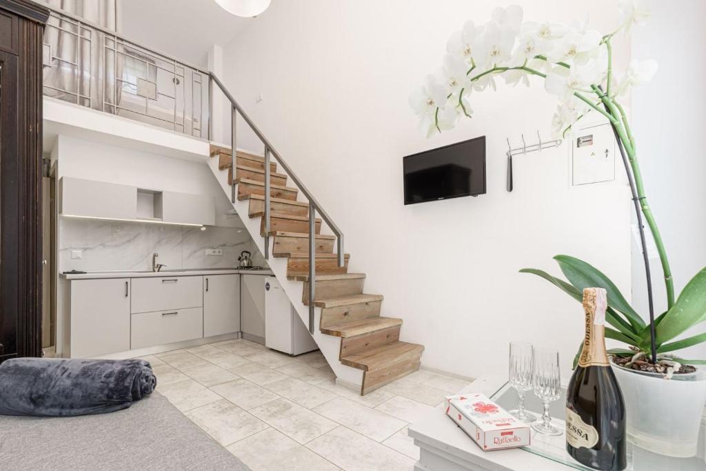uma sala de estar com uma escada e uma cozinha em Апартаменты в гостевом доме em Odessa