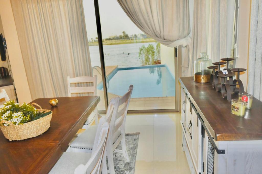 a dining room with a table and a swimming pool at Amwaj Resort For Families Only in Al Khobar