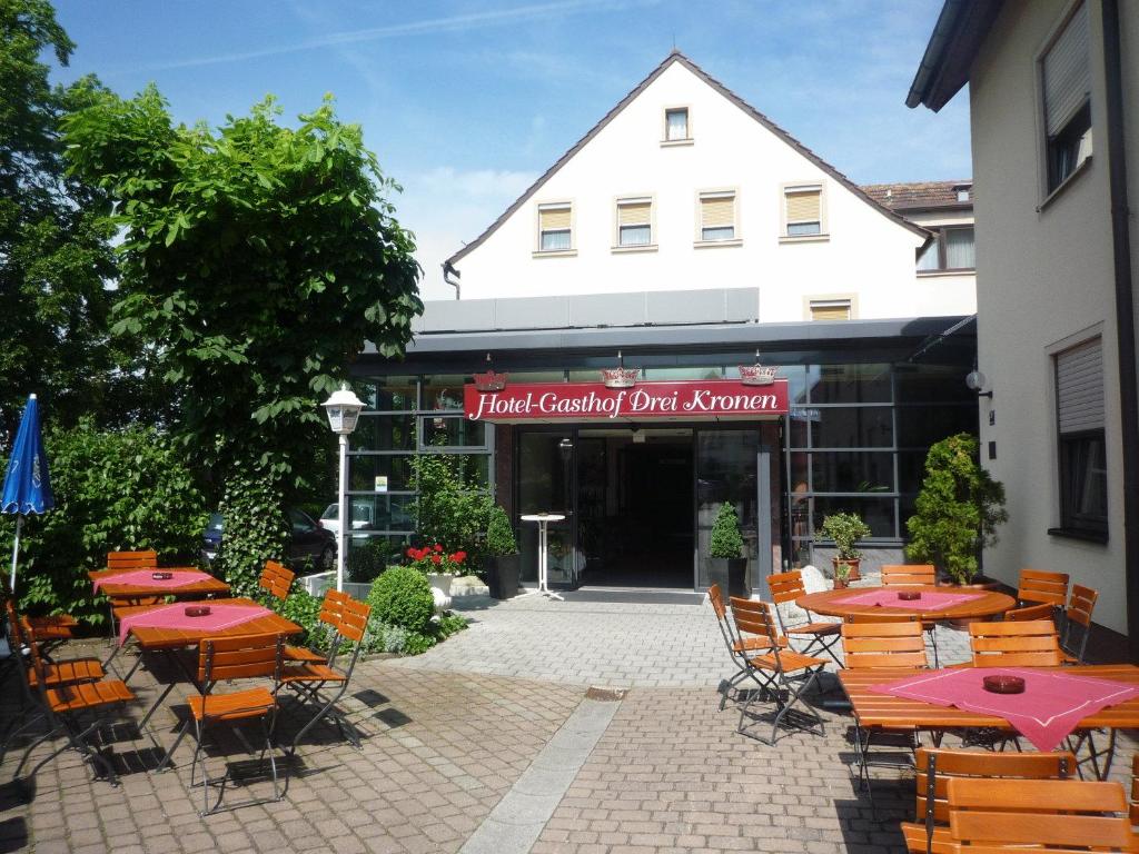 eine Gruppe von Tischen und Stühlen vor einem Gebäude in der Unterkunft Hotel Drei Kronen in Burgkunstadt