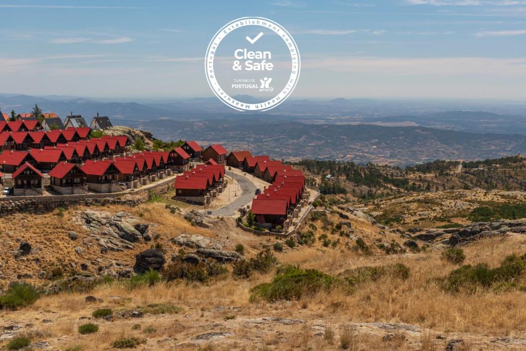vistas a una montaña con edificios rojos en una colina en Luna Chalets da Montanha - Serra da Estrela en Covilhã