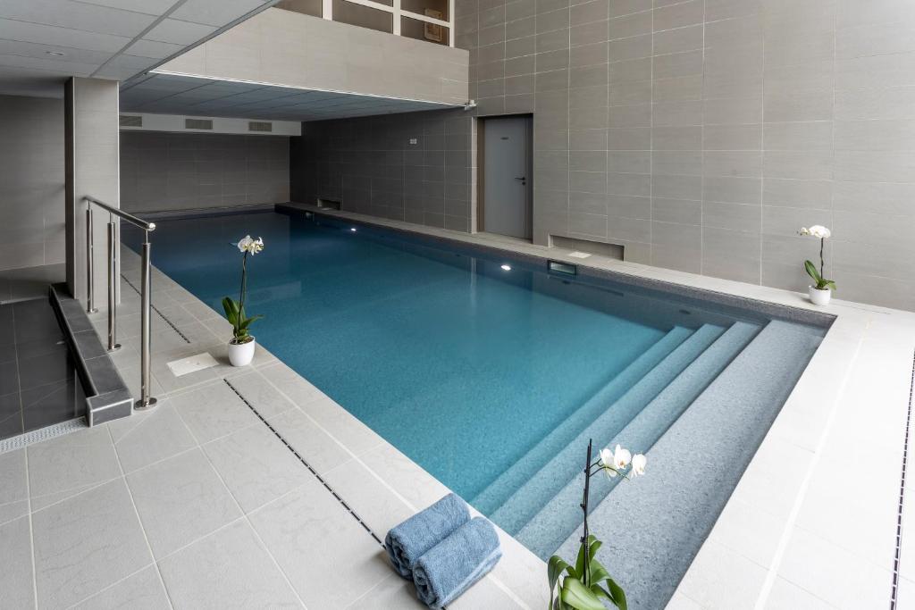 a large swimming pool in a room with tiles at Nemea Appart Hotel Europe Velizy Villacoublay in Vélizy-Villacoublay