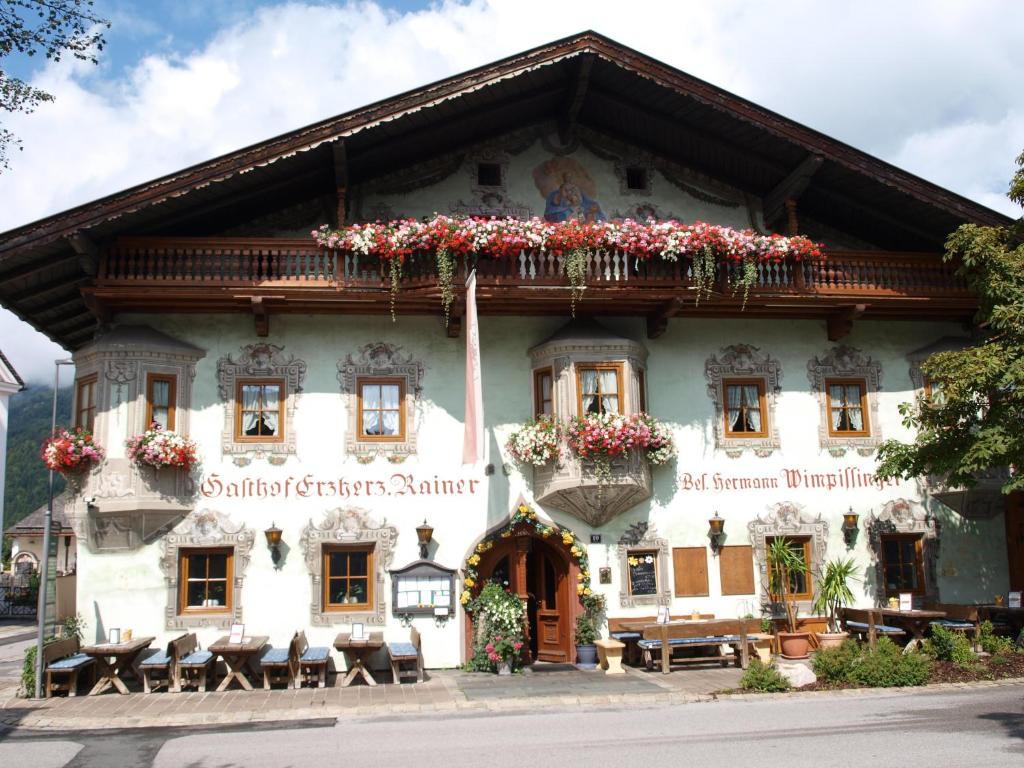 een gebouw met bloemen aan de voorkant bij Gasthof Erzherzog Rainer - Zimmer und Ferienwohnung in Kössen