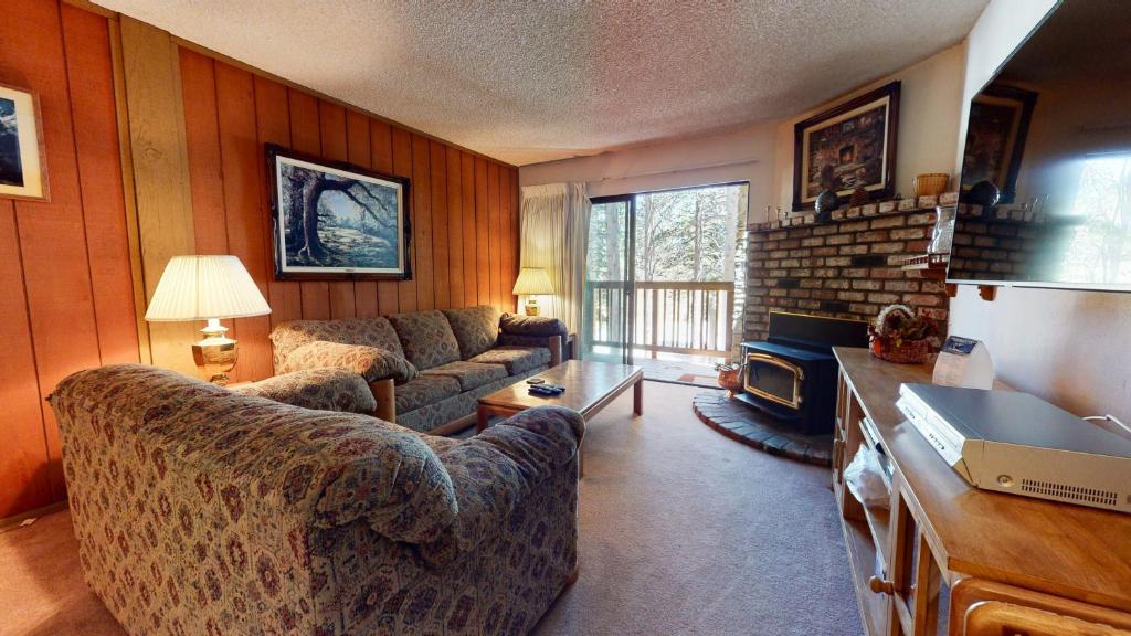 een woonkamer met een bank en een open haard bij Summit Condominium #267 Condo in Mammoth Lakes