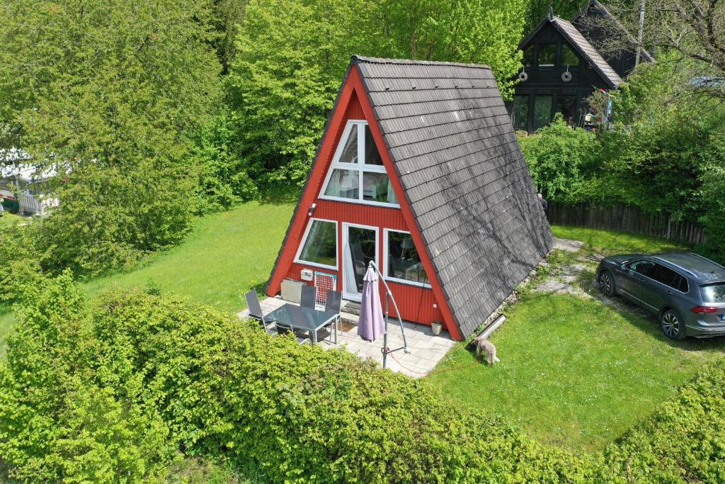 een uitzicht op een kleine rode hut met een dak bij Ferienhäuser Campingplatz in Kinding