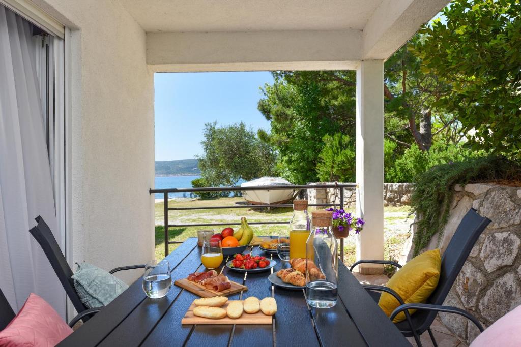 een tafel met eten en drinken op een patio bij Malako Family Apartments in Seline