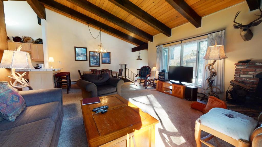 a living room with a couch and a tv at Chateau De Montagne #23 Condo in Mammoth Lakes