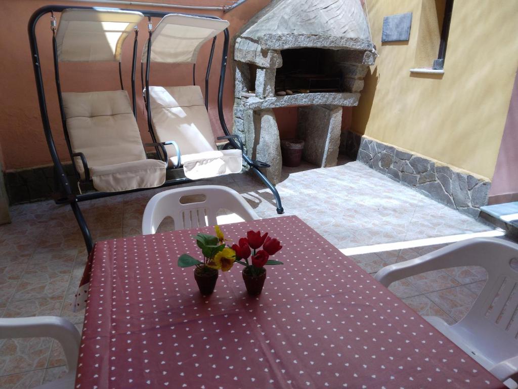 een tafel met bloemen en een open haard bij CASA VACANZA BariSardo in Bari Sardo