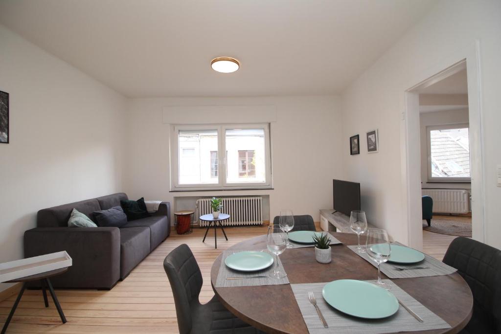 uma sala de estar com uma mesa e um sofá em Appart Nicolas em Eupen