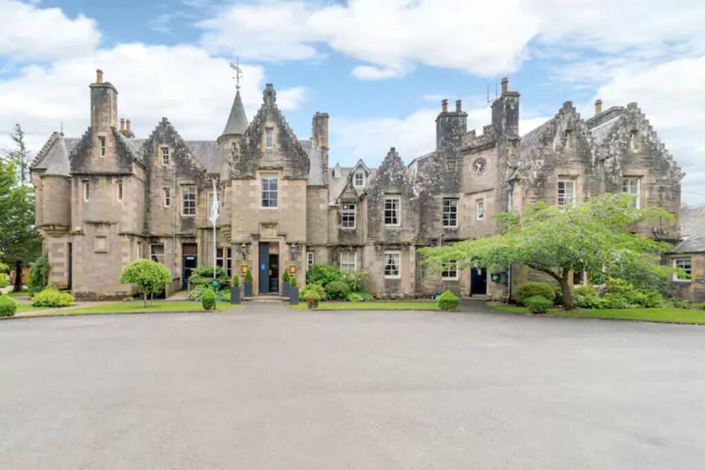 an old castle with a large driveway in front of it at Stewart Apartment - A unique Apartment in countryside park with WIFI and access to bar and pool in Perth