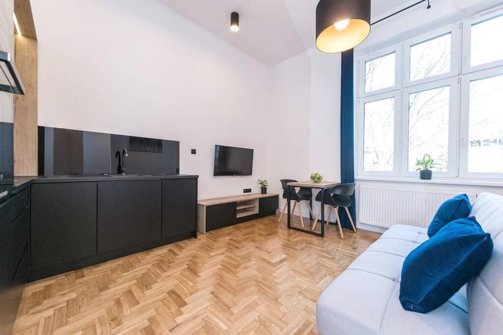 uma sala de estar com um sofá branco e uma mesa em Studio Matejki B em Bielsko-Biala