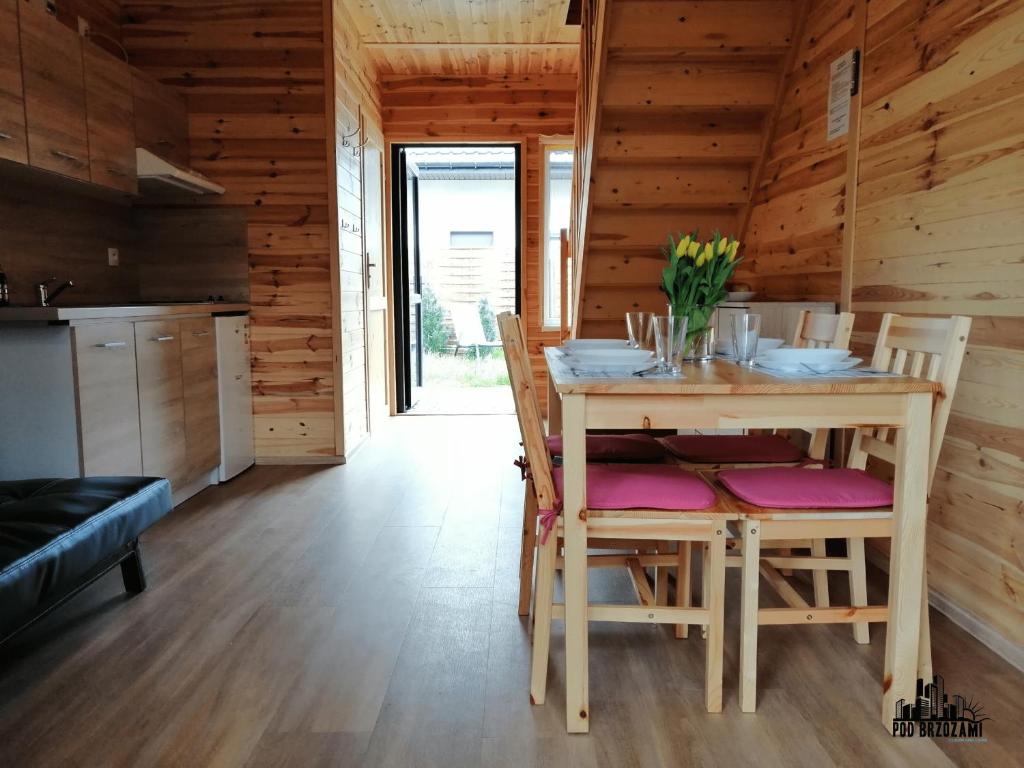 uma cozinha e sala de jantar com mesa e cadeiras em Pod Brzozami Apartamenty Domek Ustronny em Ustronie Morskie