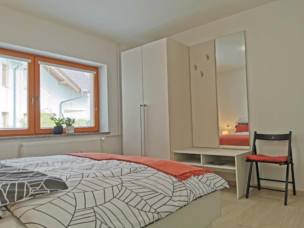 a bedroom with a bed and a chair and a window at Apartment Vida in Bled